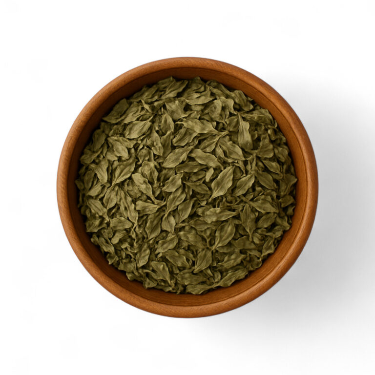 Cuenco redondo marrón con albahaca en hojas deshidratadas sobre fondo blanco.